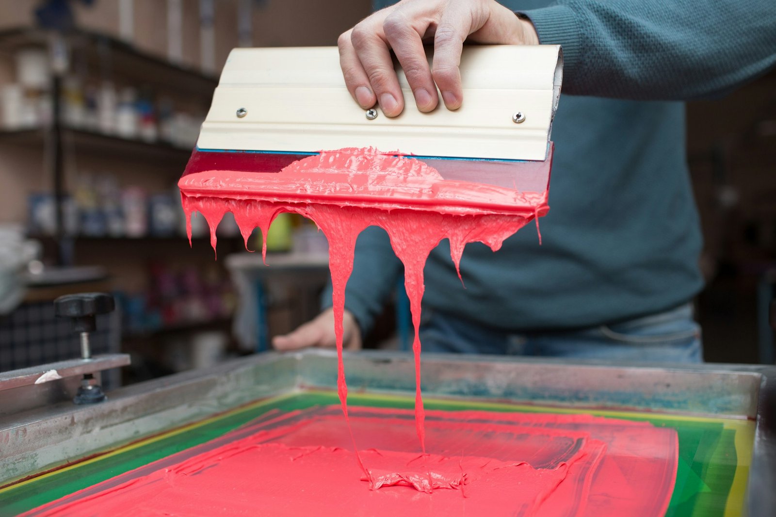 Silk screen printing. Serigraphy. Color paints and fabric. Plastisol paint and squeegee